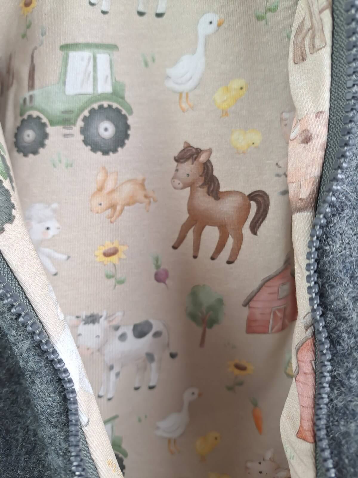 Walkoverall aus Wollfleece grau meliert mit Bauernhof sand